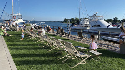 Guests at the Shoals Hotel in Southold, N.Y., enjoy food and drink on the property's lawn on the Peconic Bay.