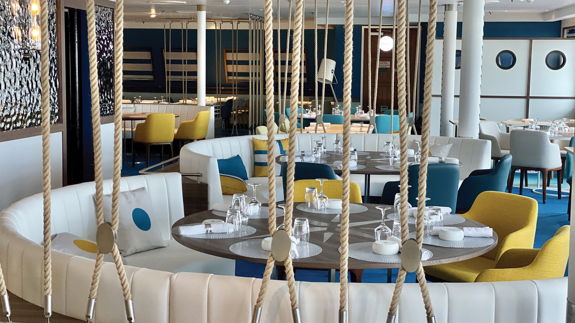 The Club Med 2's Monte Carlo restaurant weaves a chic design with nautical elements, such as ropes and wall accents resembling ocean waves.
