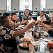 A group celebrates over a meal at a Kimpton hotel.