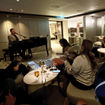ASTA River Cruise Expo attendees on the Riverside Mozart sing in The Cove piano bar.