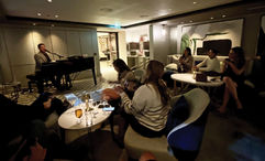 ASTA River Cruise Expo attendees on the Riverside Mozart sing in The Cove piano bar.