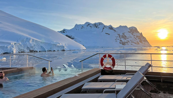 Guests enjoy a sunset over the Lemaire Channel from the heated pool on the deck of the SH Vega. Guests enjoy a sunset over the Lemaire Channel from the heated pool on the deck of the SH Vega.