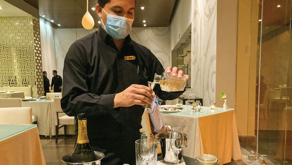 A server mixes a cocktail at the table at Cocina de Autor.