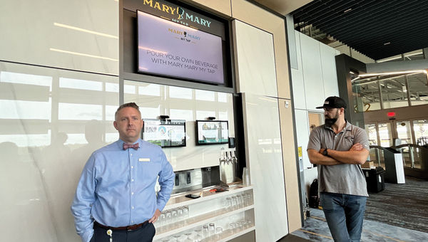 Brightline vice president of guest experience George Edwards and Tended Bar co-founder and CEO Justin Honeysuckle stand in front of the Mary Mary My Tap bar.