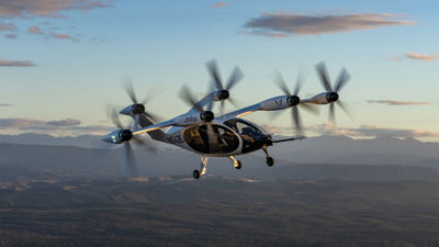 A full-scale prototype of Joby's S4 four-passenger electric air taxi flies above the company's manufacturing and flight-test facilities in Marina, California.