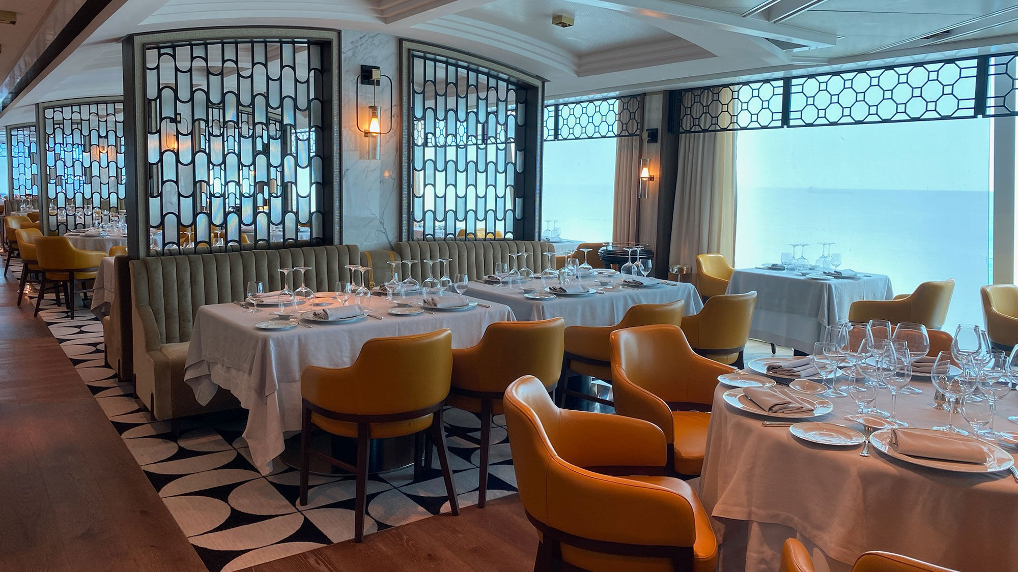 The Toscana restaurant on the Oceania Vista features a contemporary design, like curved shapes in space dividers and art made of small rectangular tiles.