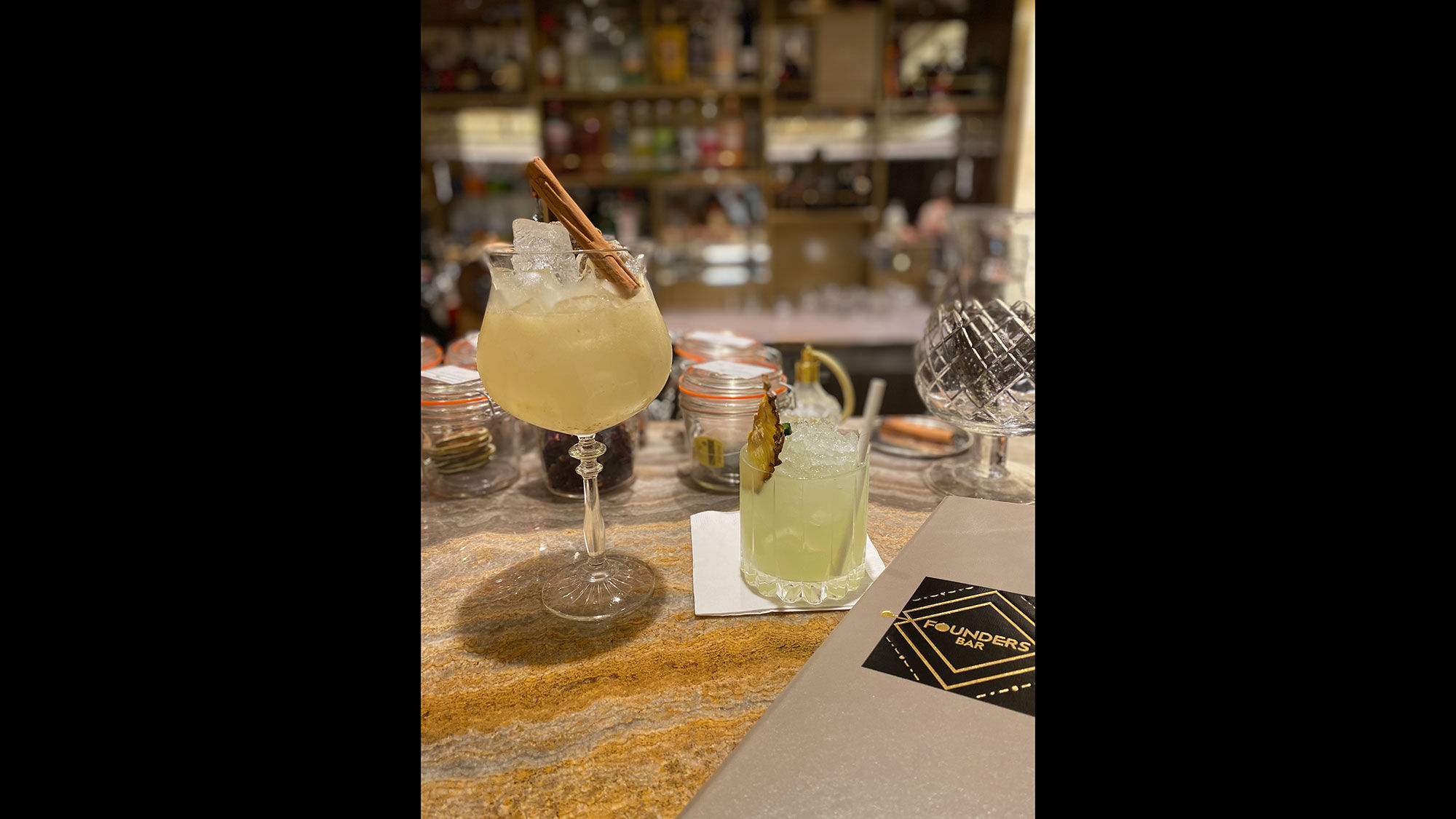 The Figstation is made with Bombay Sapphire gin, lemon juice, fig jam and Fever Tee Indian tonic. On the right is Eric's Mezcalita with juice, pineapple puree, jalapeno and grilled pineapple. Both are served in the Founders Bar.