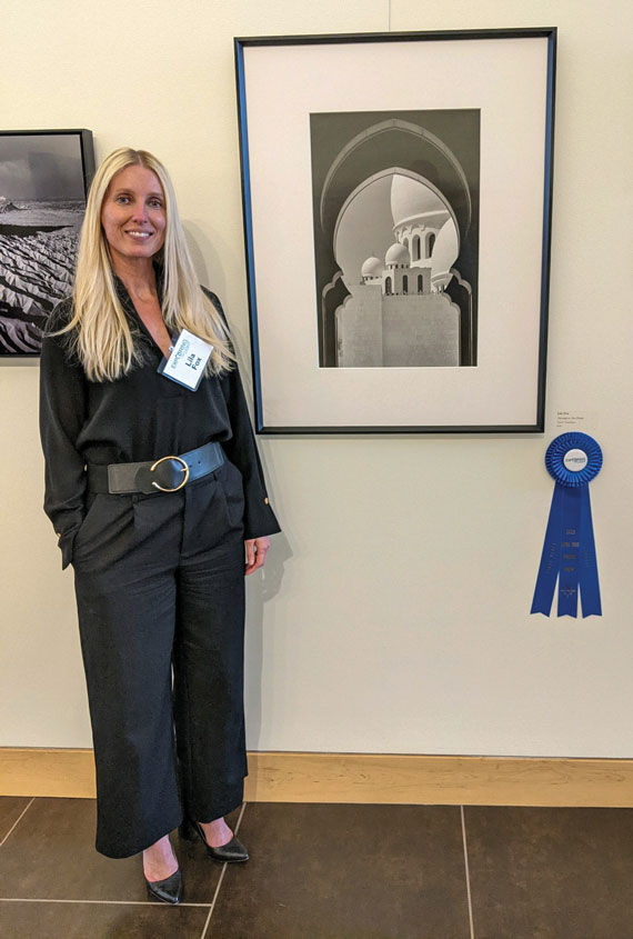 Lila Fox with one of her photos on display in a local art center.