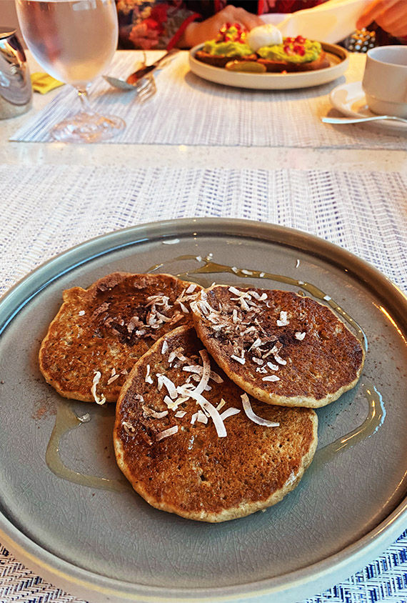 Banana pancakes topped with coconut and drizzled with syrup are served at the Aquamar Kitchen.
