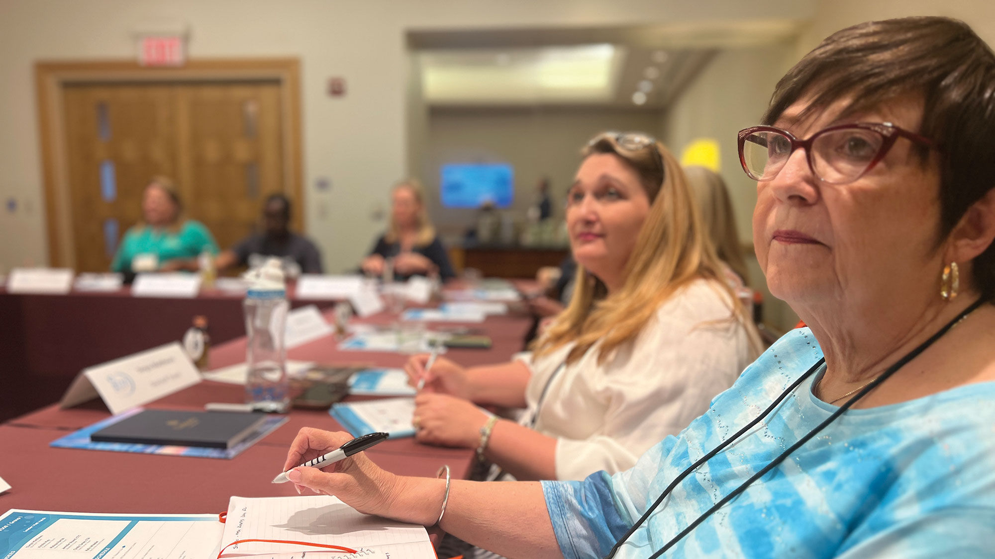 Tara Hyland, owner of Tara Hyland Travel/Departure Lounge from League City, Texas, listens to Boardroom sessions at the 2023 Global Travel Marketplace.