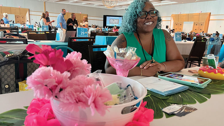 Nita Cooper of Stars N Skyes Travel in Fayetteville, Ga. at her table at the 2023 Global Travel Marketplace appointment sessions. Though table decorations aren't required, many advisors brought floral displays, globes, tablecloths, candy bowls and other accouterments to show off their agency and expertise.