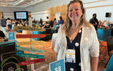 Toni Mauger of Paradise Found Travel in Marlton, N.J., at her table. Her signpost represents some of her favorite destinations, but she has a special place in her heart for Jost Van Dyke in the British Virgin Islands.