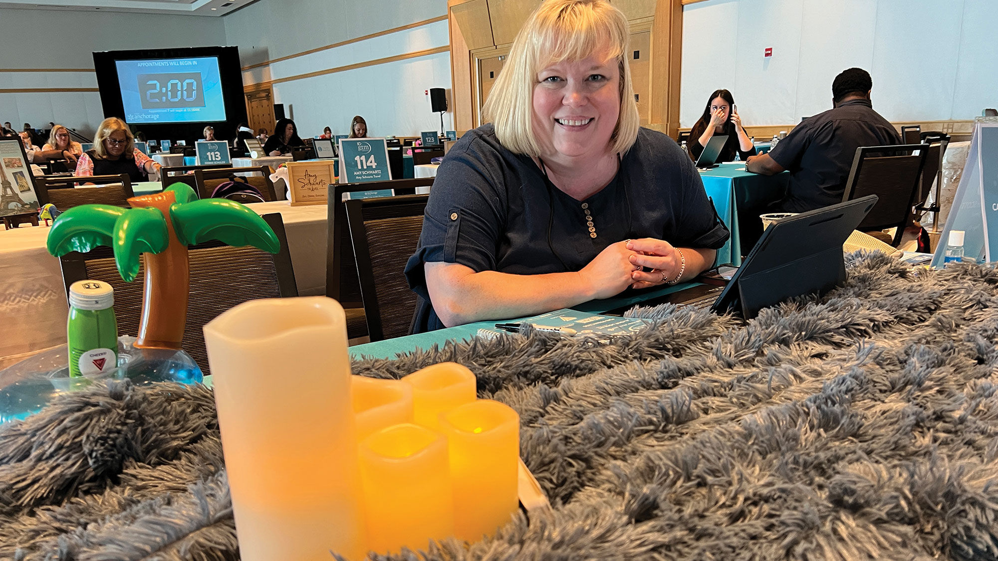 CarolBeth Scott of 3D Travel in McKinney, Texas, at her table at the 2023 Global Travel Marketplace appointment sessions. Her throw was soft and soothing.