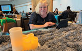 CarolBeth Scott of 3D Travel in McKinney, Texas, at her table at the 2023 Global Travel Marketplace appointment sessions. Her throw was soft and soothing.