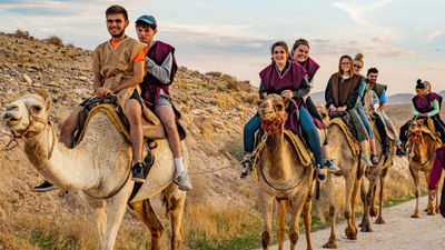 ETS Tours guests riding camels.