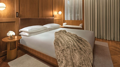 Guestrooms at the new Rome Edition are decorated with muted colors and walnut wood accents.