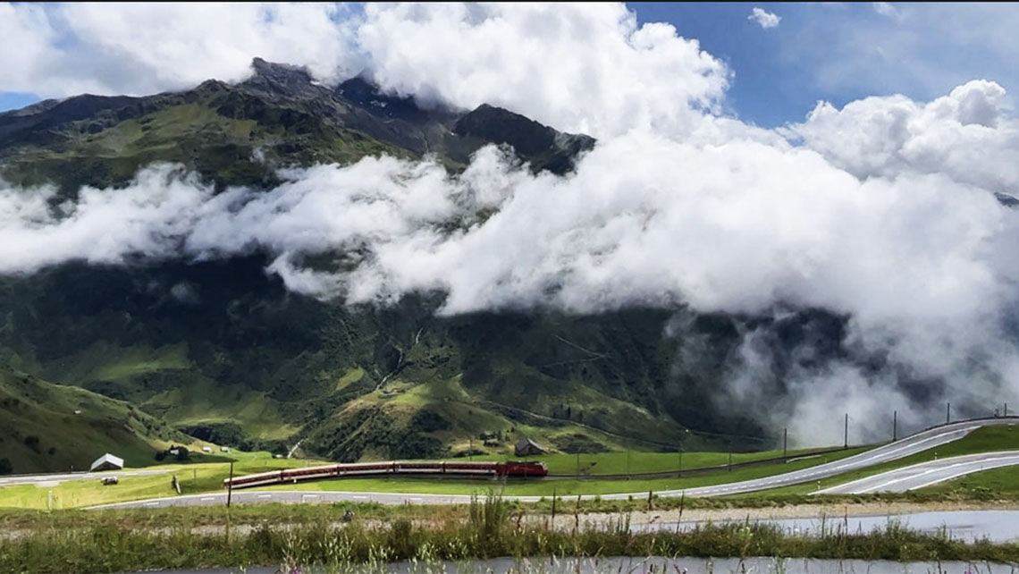 The Glacier Express beneath Swiss Mountains.