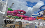 The waterslides in the Thrill Island waterpark on Icon of the Seas: raft slides to the left, single-rider slides to the right.