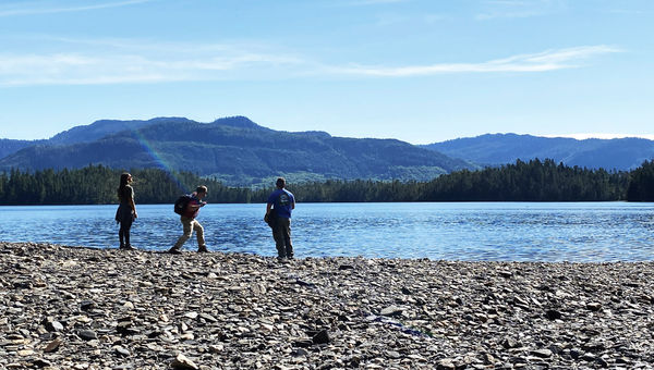 Guests on a Princess Cruises excursion skipping rocks on Mahoney Lake after a bumpy ATV ride.