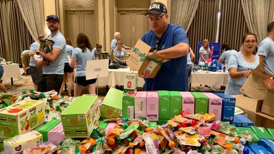 Signature Travel Network CEO Alex Sharpe helps sort donated items in Maui.