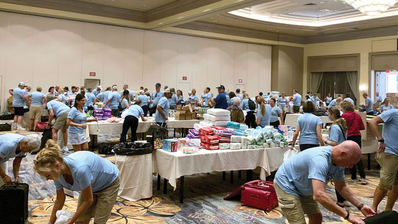 Attendees of Signature Travel Network’s Owners' Meeting sort donations to go to those affected by the Maui wildfires.