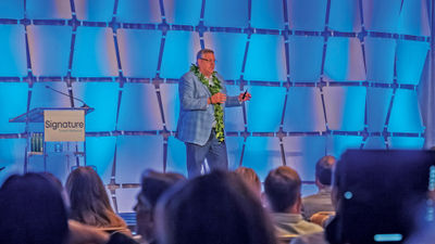 Signature president and CEO Alex Sharpe on stage at the 2023 Owner's Meeting.
