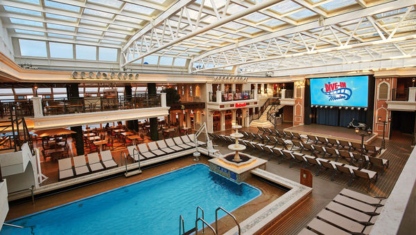 The Carnival Venezia's Lido pool is under a retractable roof and is boxed in by a bar, coffee shop, two takeaway food venues, tables and a second-floor overlook. The Carnival Venezia's Lido pool is under a retractable roof and is boxed in by a bar, coffee shop, two takeaway food venues, tables and a second-floor overlook.
