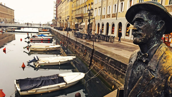 A statue of Irish author James Joyce on the Ponte Rosso bridge crossing the Grand Canal. A statue of Irish author James Joyce on the Ponte Rosso bridge crossing the Grand Canal.