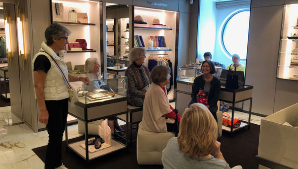 About a dozen passengers aboard the Explora I gather in The Journey shop.