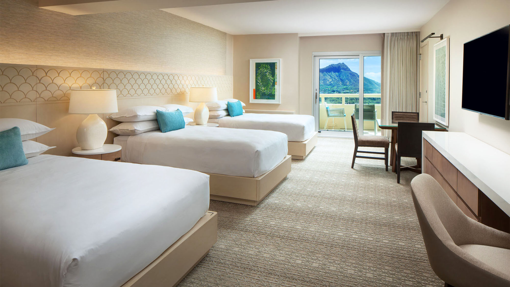 A Large Luxury guestroom at the Sheraton Waikiki features three double beds and an ocean view.