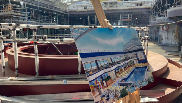 A rendering on an easel shows what the Queen Anne’s midship pool area will look like.