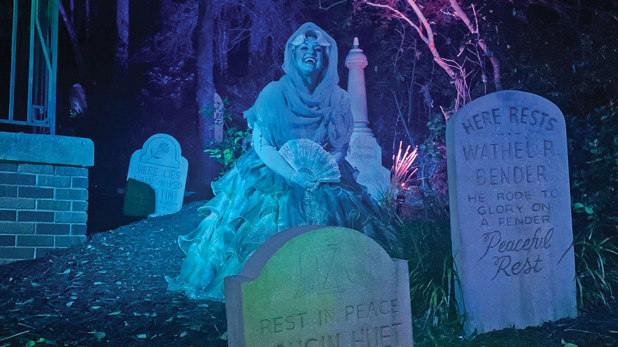 Renata, one of the ghostly residents of the Haunted Mansion, entertains guests from the graveyard.