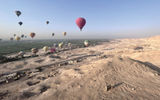A number of hot air balloons soar over the Nile River Valley and the desert sands of the Valley of the Kings just outside of Luxor, including a number of Viking guests on excursion during a sailing aboard the Viking Aton.
