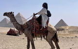The author rides a camel named Casanova against the backdrop of the Pyramids of Giza while on a press trip with Viking for the Viking Aton.