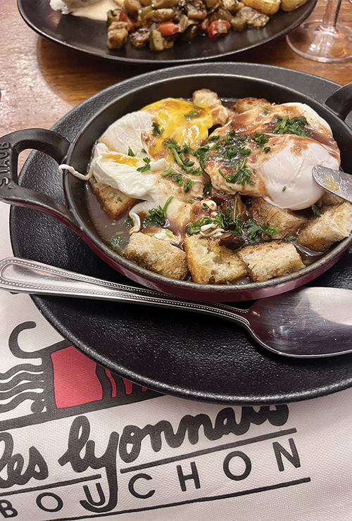 Tripe sausage with poached eggs and potatoes at Bouchon Les Lyonnais in Lyon, France.