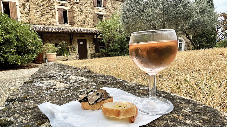 A glass of chilled rose served with shaved black truffles over baguette slices at Ayme Truffe in Grignon, where guests on the inaugural Soulful Epicurean Expeirence itinerary went on a truffle hunting excursion.
