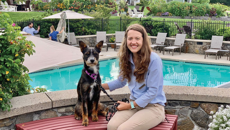 A foster dog is accompanied by a staff member at Inn by the Sea in Cape Elizabeth, Maine.