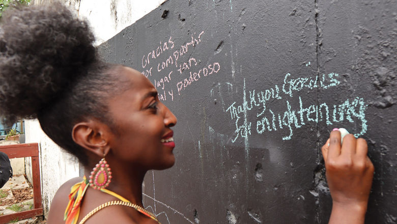 A traveler writes a thank-you message on a wall in Loiza, Puerto Rico.