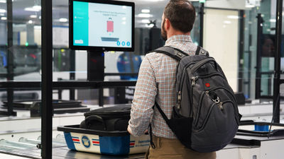 Flyers at TSA's self-screening checkpoint in Las Vegas receive instruction via video monitor.