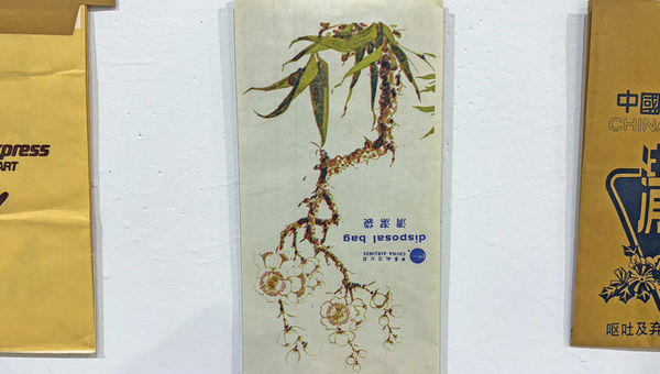 A barf bag from China Airlines with a floral image that appears right side up to anyone using the bag for its intended purpose.