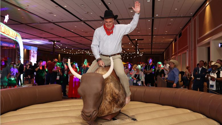 ASTA president and CEO Zane Kerby rode a mechanical bull during the Jubilee welcoming event at the Travel Advisor Conference in Dallas.