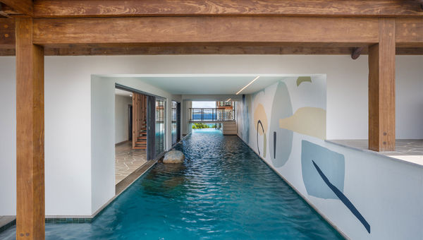A canal-style pool weaves through indoor and outdoor areas of Moskito Island’s Cape Stout estate.