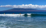 Surfers at Kaanapali Surf School in Maui hit the waves in July with the island of Molokai serving as the backdrop.