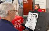 Jen Cratsley of CM Travel poses for a caricature sketch at the General USA travel protection booth during the CruiseWorld trade show. Her partner who also sells travel, Mark McRorie, also sat for a drawing. The two launched their business a year and a half ago and are building it up to eventually hand it off to their daughter who lost her arm as a teenager.