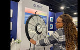 Stephanie Mays, a travel advisor at Perpetual Vacations, spins a wheel of prizes at the MSC Cruises booth, which included baseball caps, mouse pads, tote bags and luggage straps (she won a mouse pad).