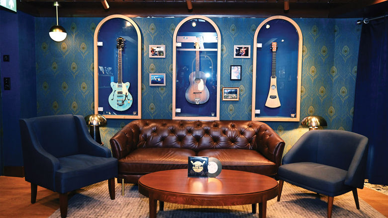 Guitars hang on the walls in glass cases in the Quietly Making Noise speakeasy aboard the Margaritaville at Sea Islander, including one that belonged to Jimmy Buffett.