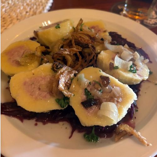 At Travel Hostel, dumplings stuffed with smoked pork sausage, served with crispy onions on a bed of caramelized cabbage. At Travel Hostel, dumplings stuffed with smoked pork sausage, served with crispy onions on a bed of caramelized cabbage.