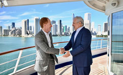 Russell Galbut, managing principal at Crescent Heights, left, shakes hands with Harry Sommer, president and CEO of  Norwegian Cruise Line Holdings.