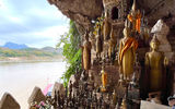 Pak Ou Caves, a sacred Buddhist site tucked into a limestone cliff overlooking the Mekong and filled with thousands of golden Buddha statues.