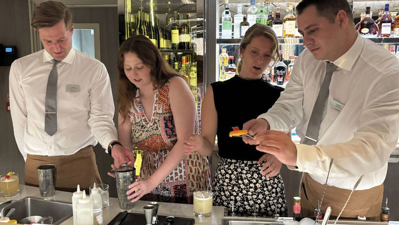 Riverside Debussy bartenders give Travel Weekly's Brinley Hineman and her guest an impromptu lesson on how to make the perfect whiskey sour.